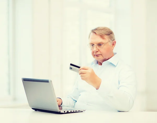 Hombre con laptop y tarjeta de crédito —  Fotos de Stock