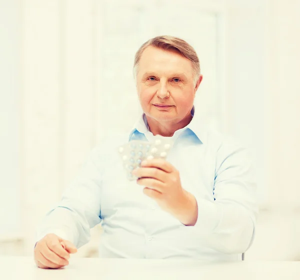 Old man with pack of pills — Stock Photo, Image