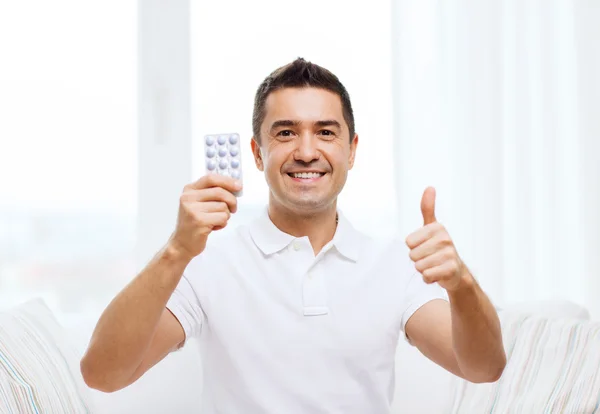 Uomo felice mostrando pacchetto di pillole — Foto Stock