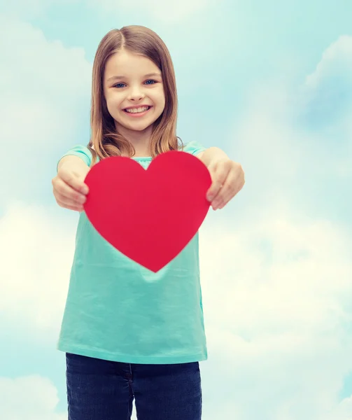 Sorrindo menina dando coração vermelho — Fotografia de Stock