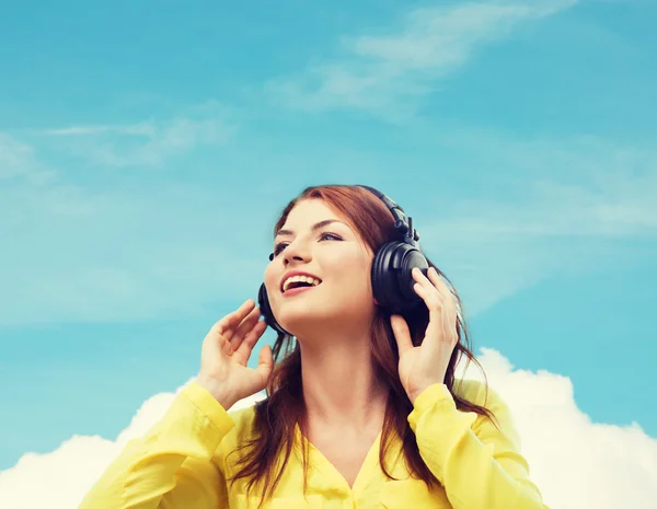 Sonriente chica joven en los auriculares — Foto de Stock