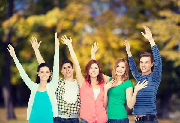 Группа улыбающихся студентов, машущих руками — стоковое фото