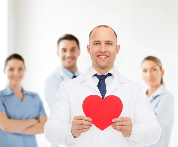 Улыбающийся доктор с красным сердцем — стоковое фото