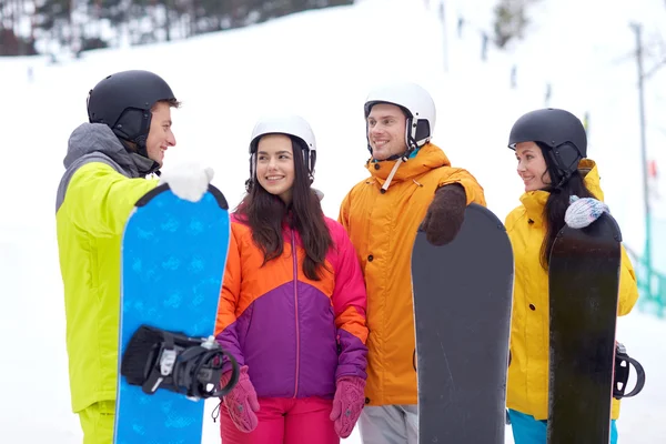 Vänner i hjälmar med snowboards — Stockfoto