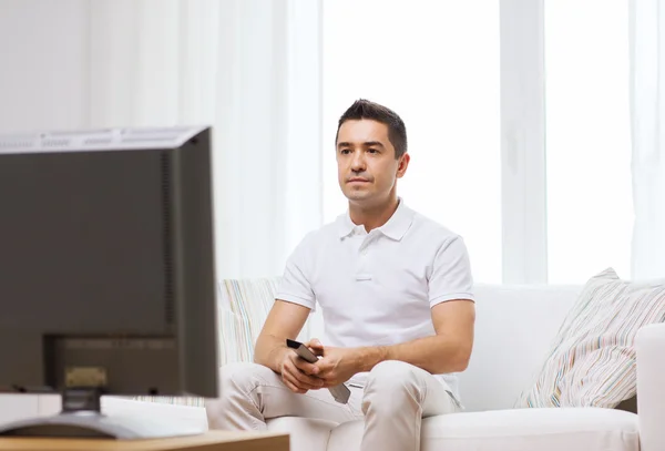 Homme avec télécommande regardant la télévision — Photo