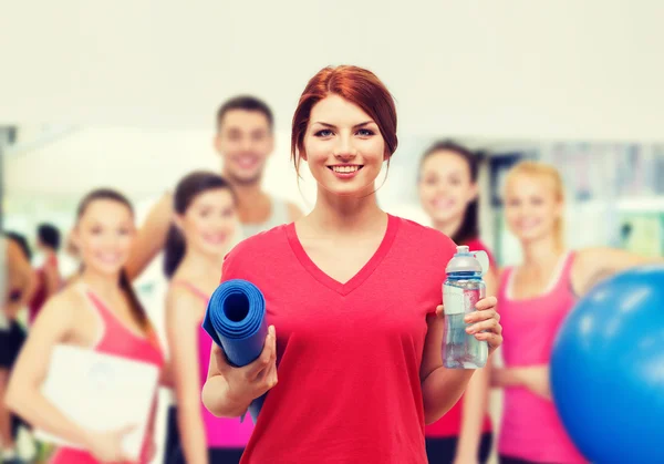 Chica sonriente con agua después de hacer ejercicio — Foto de Stock