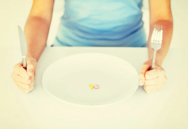 Woman with plate and tablets — Stock Photo, Image