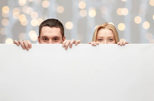 Paar verbergen achter leeg bord — Stockfoto