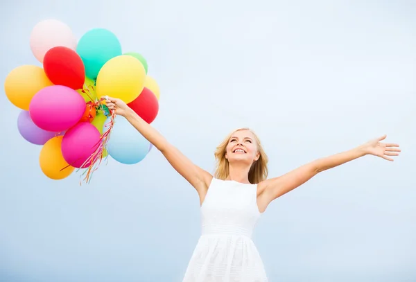 Женщина с разноцветными воздушными шарами снаружи — стоковое фото