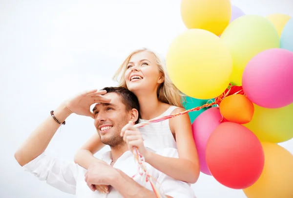 Par med färgglada ballonger på seaside — Stockfoto