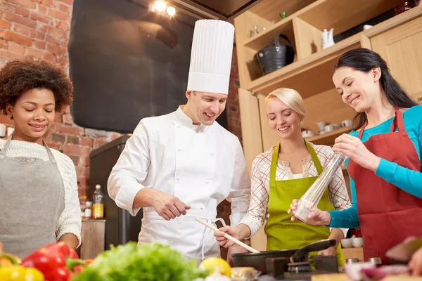 Mujeres y cocinero cocinando en la cocina — Foto de Stock