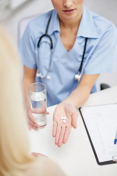 Médico dando pílulas para paciente — Fotografia de Stock