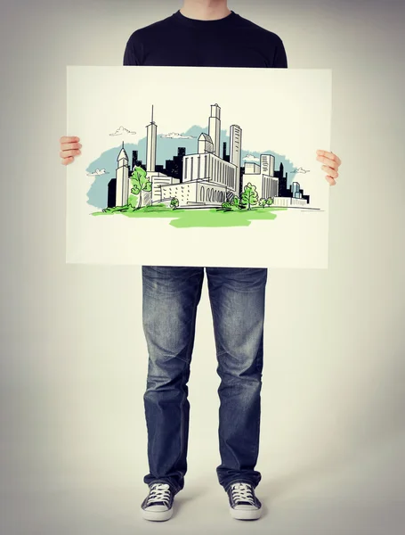 Человек показывает белую доску с городским рисунком — стоковое фото