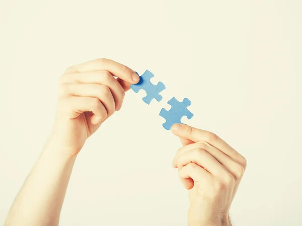 Two hands trying to connect puzzle pieces — Stock Photo, Image