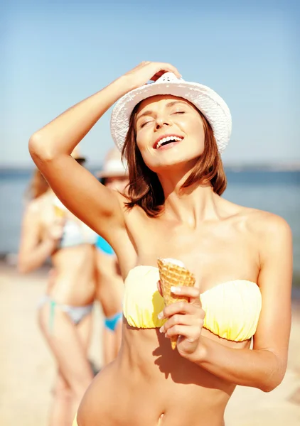 Tjej i bikini äta glass på stranden — Stockfoto