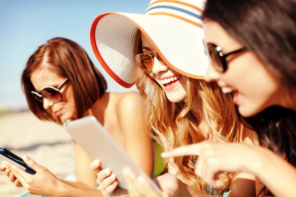 Девушки с планшетным ПК на пляже — стоковое фото