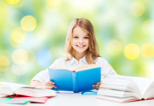 Счастливая студентка, читающая книгу в школе — стоковое фото