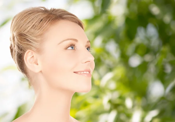 Schöne junge Frau Gesicht über grünem Hintergrund — Stockfoto