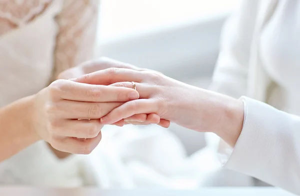 결혼 반지를 끼고 있는 레즈비언 커플들의 손을 꽉 잡고 있는 모습 — 스톡 사진