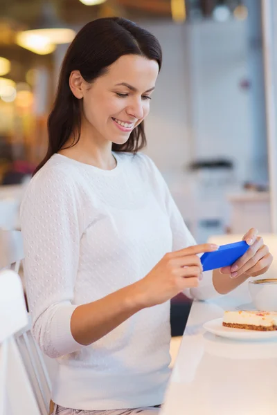 Femme souriante avec smartphone et café au café — Photo