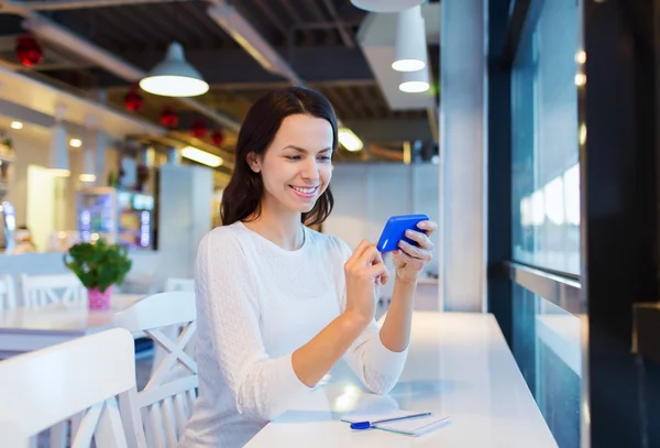 Mulher sorridente com smartphone no café — Fotografia de Stock