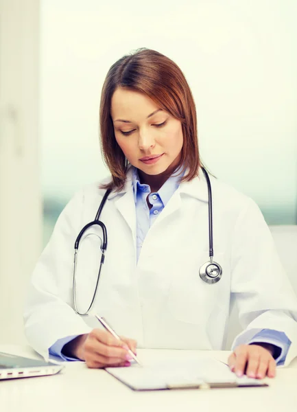 Médico ocupado con computadora portátil y portapapeles — Foto de Stock