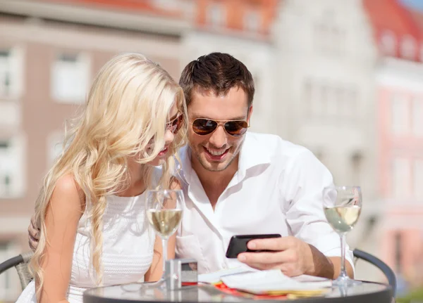 Couple looking at smartphone in cafe — Stock Photo, Image