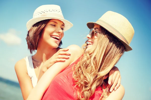 Girls in hats on the beach Stock Image