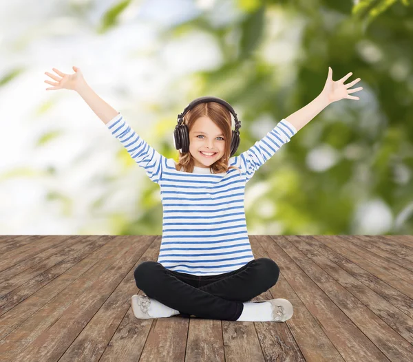 Gelukkig meisje met koptelefoon luisteren naar muziek — Stockfoto