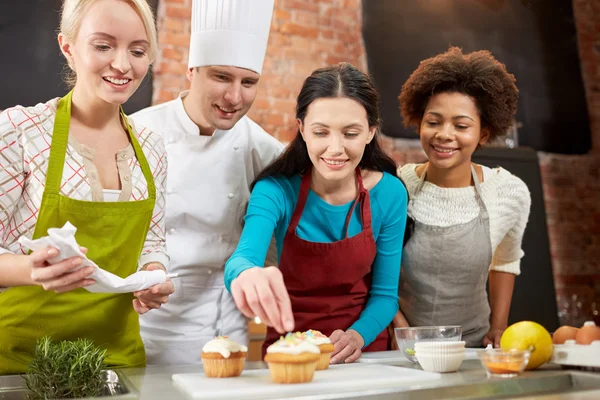 Mulheres felizes e cozinheiro chef assar na cozinha — Fotografia de Stock