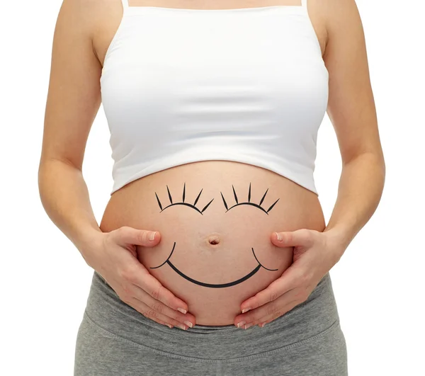 Primer plano de la mujer embarazada tocando su barriga desnuda Imágenes de stock libres de derechos
