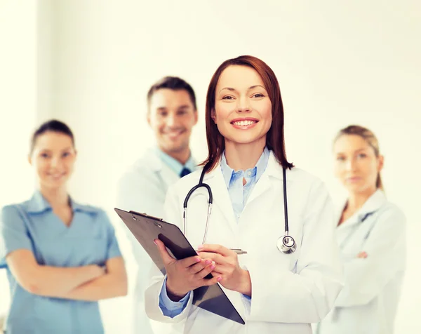 Médecin femme souriante avec presse-papiers — Photo