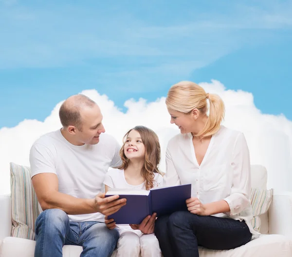 Famiglia felice con libro a casa — Foto Stock