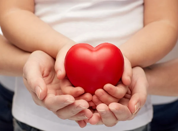 Close up of woman and girl hands holding heart — Stock Photo, Image