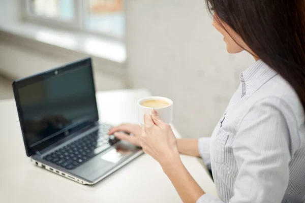 Рядом женщина с ноутбуком, пьющая кофе — стоковое фото