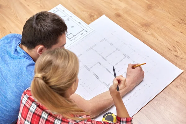 Close up of couple with  blueprint at home — Stock Photo, Image