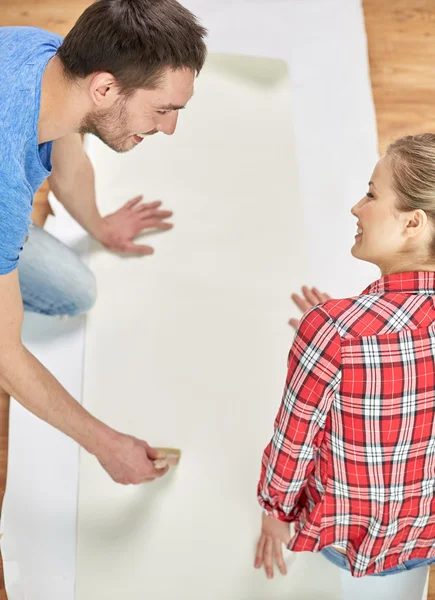 Gros plan de couple enduisant papier peint avec de la colle — Photo