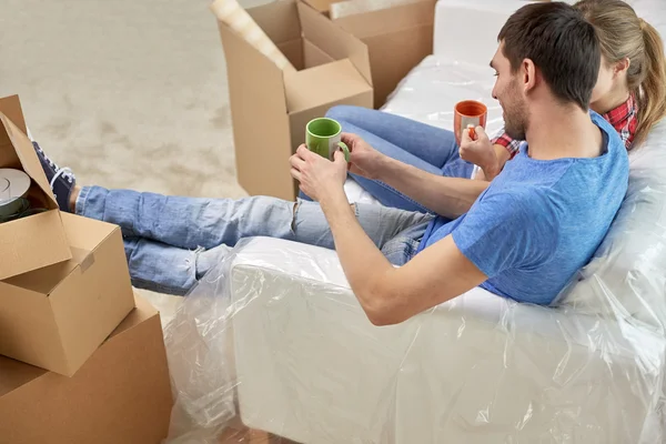 Feliz pareja relajándose en el sofá en el nuevo hogar —  Fotos de Stock