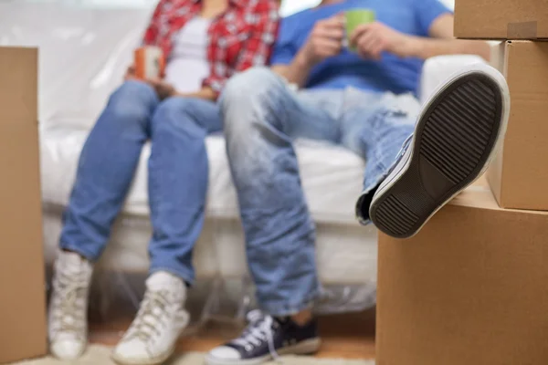 Close up de casal relaxante no sofá em nova casa — Fotografia de Stock