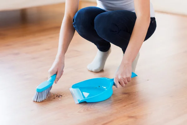 Close up of woman with brush and dustpan sweeping — Stock Photo, Image