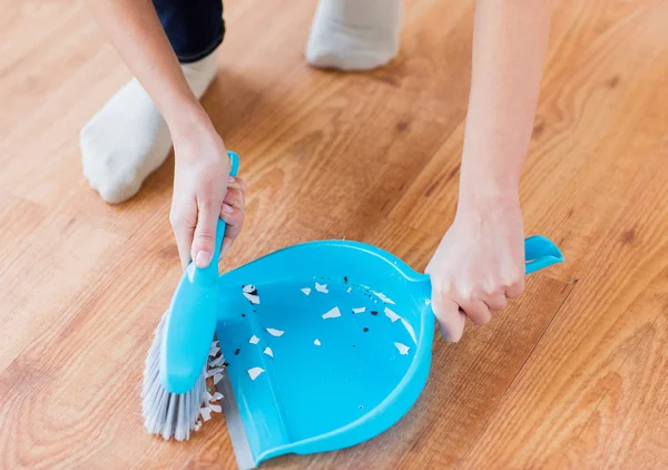 Close up of woman with brush and dustpan sweeping — Stock Photo, Image