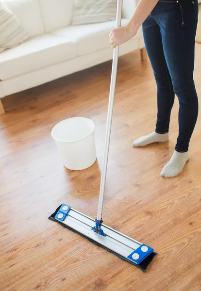 Close up de mulher com esfregão chão de limpeza em casa — Fotografia de Stock