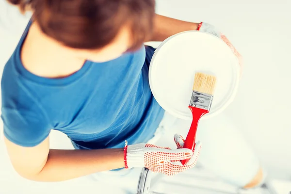 Woman with paintbrush and paint pot — Stock Photo, Image