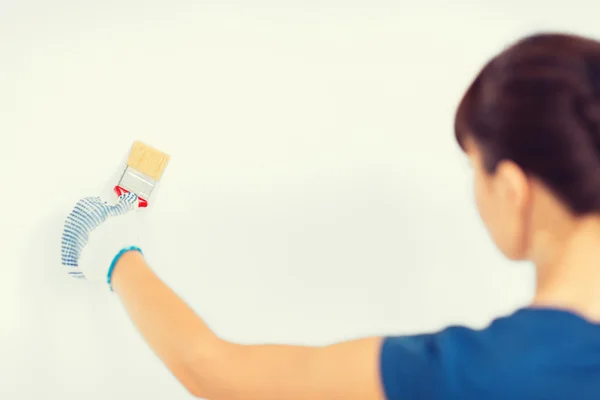 Femme avec pinceau colorant le mur — Photo