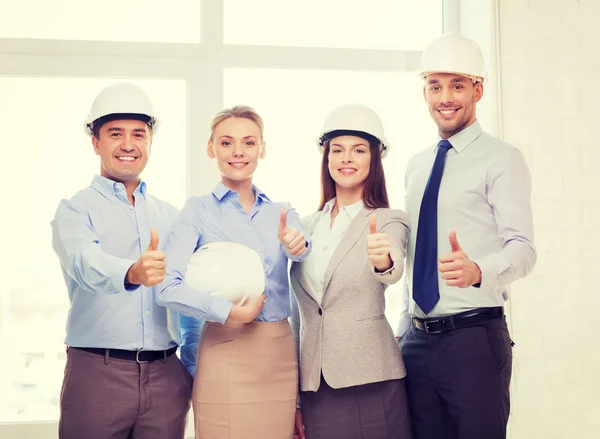 Feliz equipo de negocios en la oficina mostrando pulgares hacia arriba — Foto de Stock