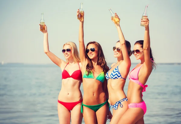 Groupe de jeunes femmes souriantes buvant sur la plage — Photo