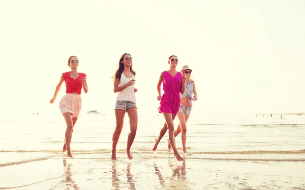 Gruppo di donne sorridenti che corrono sulla spiaggia — Foto Stock