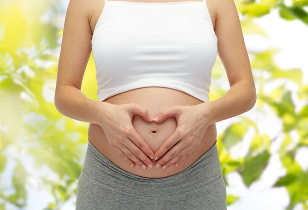 Närbild på gravid kvinna röra hennes nakna mage — Stockfoto