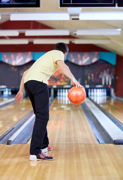 Heureux jeune homme lancer balle dans bowling club — Photo