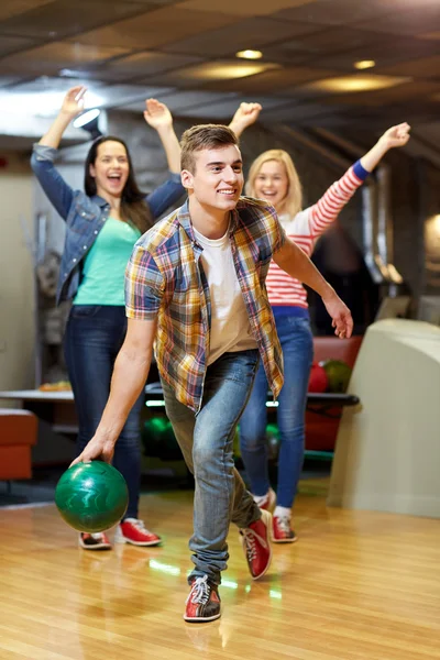 Heureux jeune homme lancer balle dans bowling club — Photo